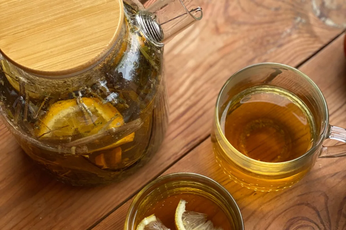 Glastassen und eine Kanne Tee mit Zitronenscheiben