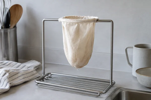 Ein Baumwollteefilter hängt an einem metallenen Trockengestell