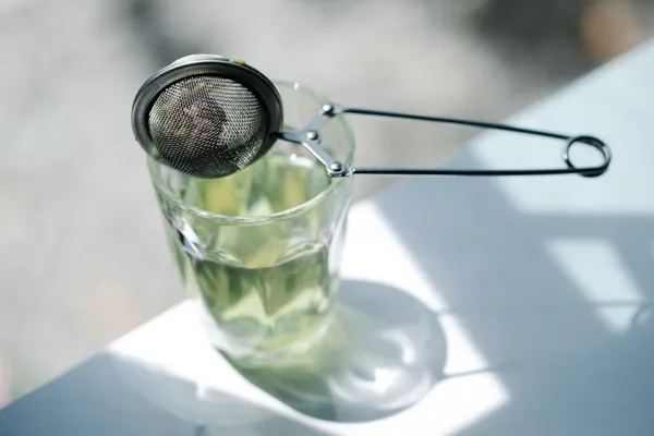 Teesieb über einem Glas Tee