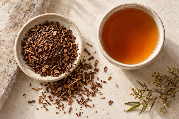 Geschnittene braune Honeybushblätter und Stiele mit einem bernsteinfarbenen Aufguss