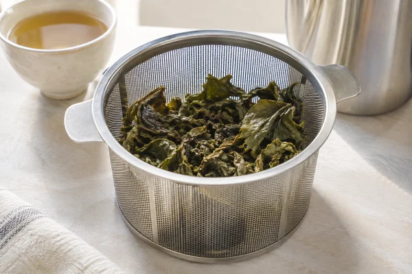Entfaltete Oolongblätter in einem geräumigen Teesieb