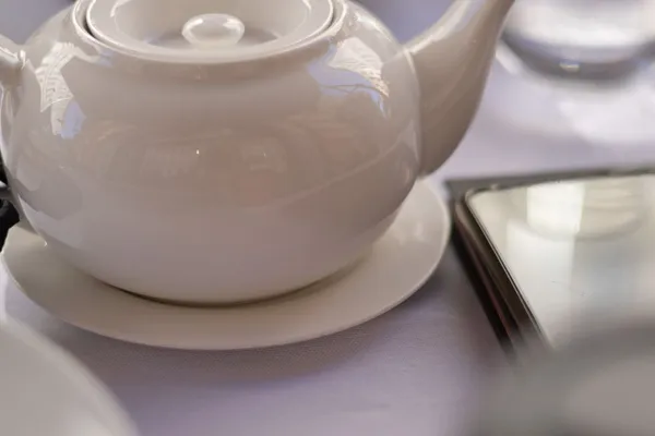 Schlichte weiße Porzellankanne auf einem Tisch