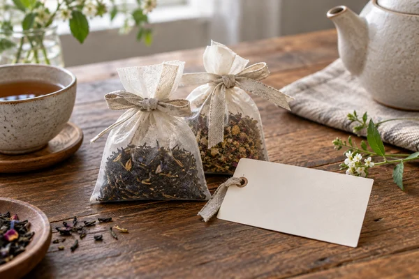 Zwei kleine Teepackungen mit Schleife und Geschenkkarte